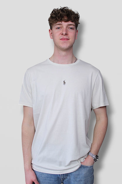 Person wearing a plain white t-shirt with a small logo on a light gray background